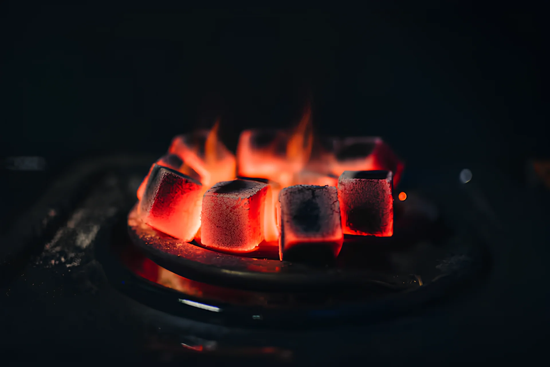 Glowing coconut charcoal cubes on a burner